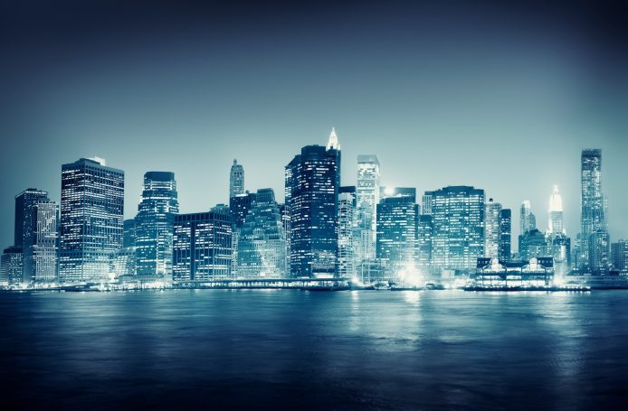 Financial Institutions City skyline at night with illuminated buildings and a moody blue atmosphere.